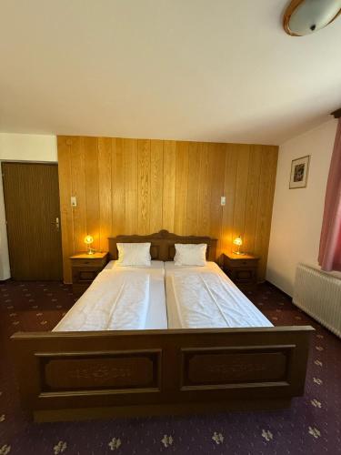 a bedroom with a large bed with wooden walls at Pension Plattenhof in Telfs