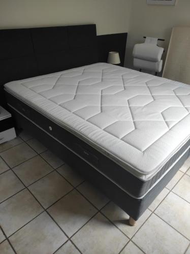 un matelas assise sur un cadre de lit dans une pièce dans l'établissement VILLA AVEC PISCINE au calme !, à Rochefort-du-Gard