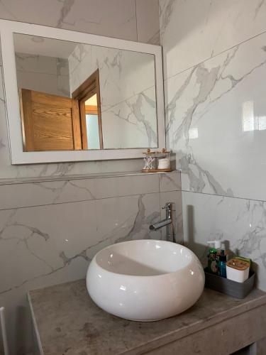 a bathroom with a white sink and a mirror at Villa Mykonos sans vis a vis in Arkou