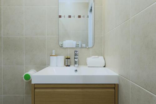 une salle de bain avec un lavabo blanc et un miroir dans l'établissement Flat 1BDR 2P Roland Garros Parc des, à Boulogne-Billancourt