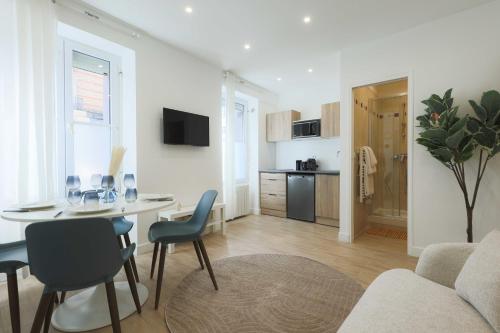 un salon avec une table et des chaises et une cuisine dans l'établissement Flat 1BDR 2P Roland Garros Parc des, à Boulogne-Billancourt