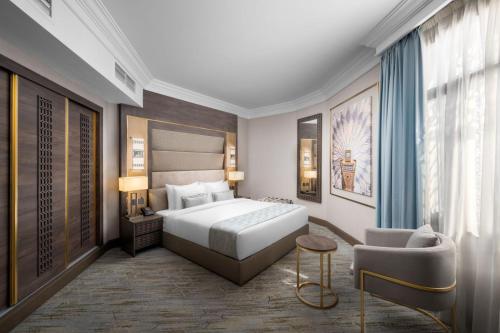 a bedroom with a king sized bed and a chair at Dar Aleiman Al Haram in Al Madinah