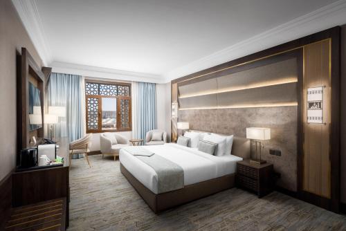 a bedroom with a large bed and a living room at Dar Aleiman Al Haram in Al Madinah