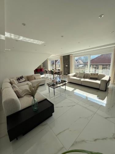 a living room with two couches and a table at L ecrin de Rosheim, villa d exception, piscine in Rosheim