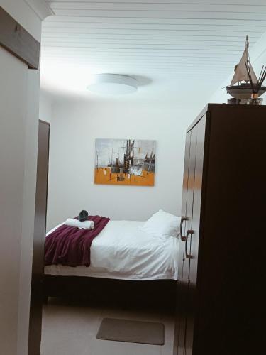 a bedroom with a bed and a picture on the ceiling at The Pool Cottage in Fish hoek