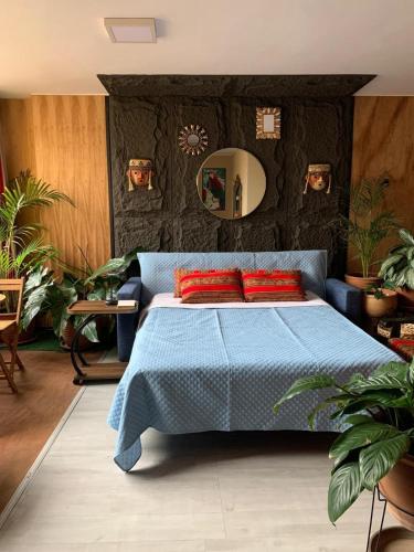a bedroom with a blue bed with red pillows at Ma maison peruvienne- departamento muy cerca aéropuerto in Lima