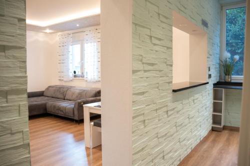 un soggiorno con una parete decorativa in pietra di Ring48 City Living - modernes Wohnen mit Wohlfühlambiente mitten im Stadtzentrum - vollausgestattete Küche, Bad mit Duschbadewanne, Parkplatz a Bayreuth