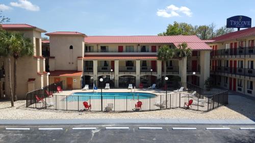 ein Hotel mit einem Pool vor einem Gebäude in der Unterkunft Tricove Inn & Suites in Jacksonville