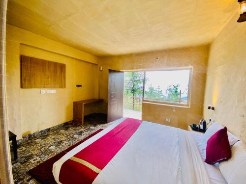 a bedroom with a large bed and a window at Staycation Premium Mud House with Balcony Mashobra - A Nature Retreat in Shimla