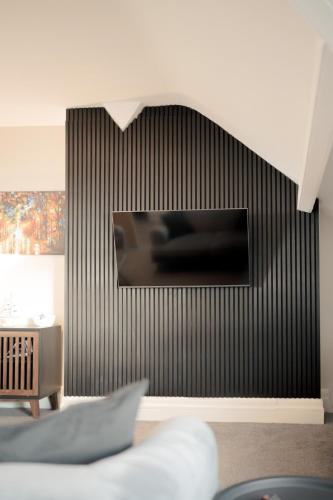 a living room with a black wall with a tv at Stunning 2 Bedroom Sea View Apartment With Parking in Rhos-on-Sea
