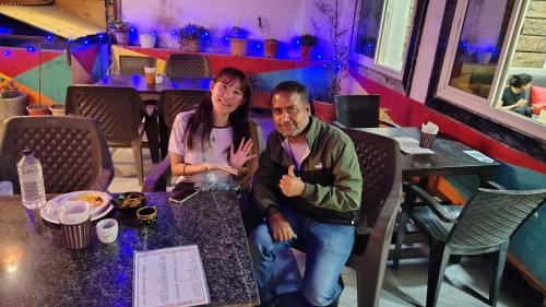 a man and a woman sitting at a table in a restaurant at Bedweiser Backpackers Hostel in Agra
