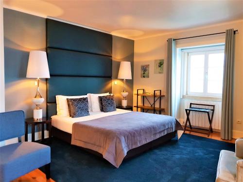 a hotel room with a large bed and a window at Quinta da Palmeira - Country House Retreat & Spa in Cerdeira
