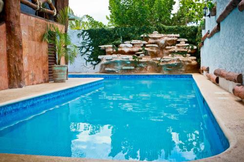 a swimming pool with a waterfall in a backyard at Villas Margaritas Holbox in Holbox Island