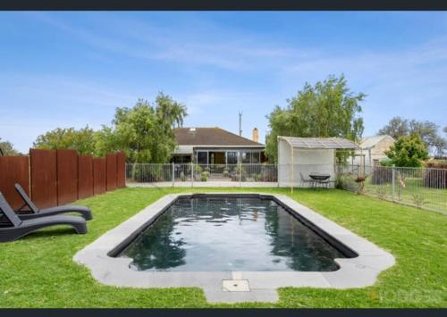 a swimming pool in the middle of a yard at SANDHU farmhouse in Moolap