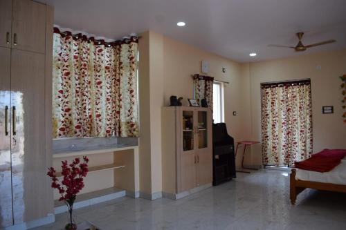 a living room with two windows and a couch at Kasotiya Mansion Homestay in Surūrnagar