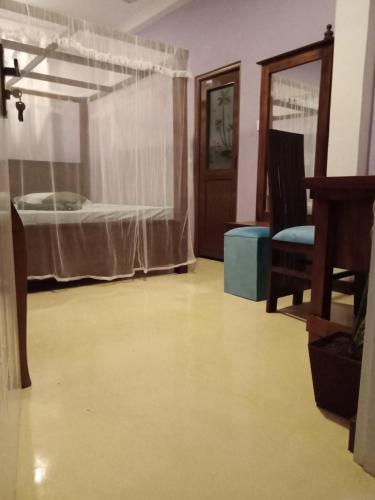 a room with a bed and a chair and a table at Homestay Midigama East, Free Washer, Wi-Fi in Midigama