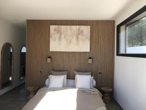 une chambre avec un grand lit avec des oreillers blancs dans l'établissement Villa garrigue, à Nîmes