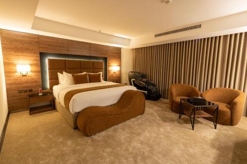 a hotel room with a bed and two chairs at فندق بلفيو بارك رويال Bellevue Park Royal Hotel in Taif