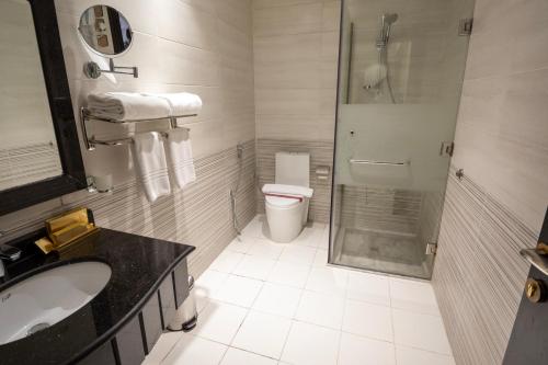 a bathroom with a shower and a toilet and a sink at فندق بلفيو بارك رويال Bellevue Park Royal Hotel in Taif