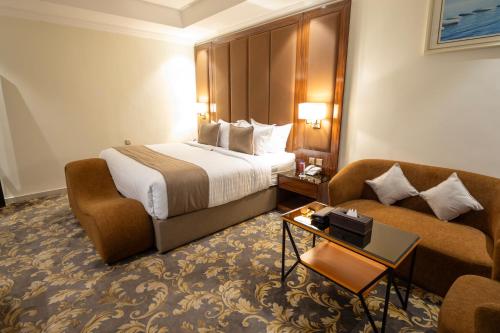 a hotel room with a bed and a couch at فندق بلفيو بارك رويال Bellevue Park Royal Hotel in Taif