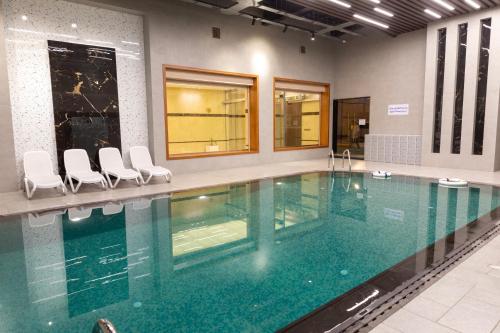 a large swimming pool with chairs in a building at فندق بلفيو بارك رويال Bellevue Park Royal Hotel in Taif
