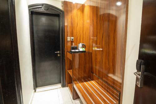 a shower with a wooden door in a bathroom at فندق بلفيو بارك رويال Bellevue Park Royal Hotel in Taif