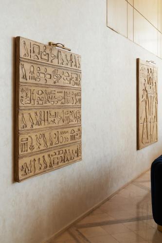 a museum exhibit with hieroglyphics on a wall at Pyramids Park Resort Cairo in Cairo