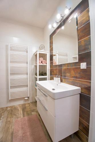 a bathroom with a white sink and a mirror at Apartmán ARTE Spišská Nová Ves in Spišská Nová Ves