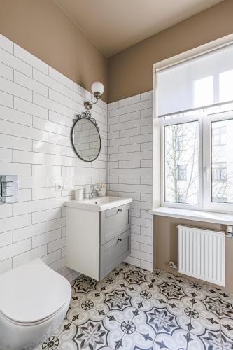 a bathroom with a toilet and a sink and a window at Harmony Apartment in Riga