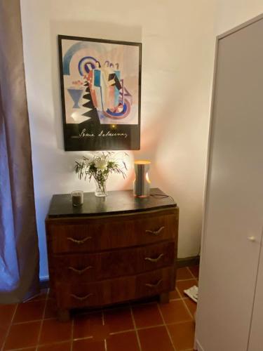 a dresser in a room with a painting on the wall at Studio avec balcon sur cour in Aix-en-Provence