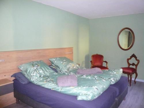a bedroom with a bed with purple sheets and a mirror at Le Rempart in Guebwiller