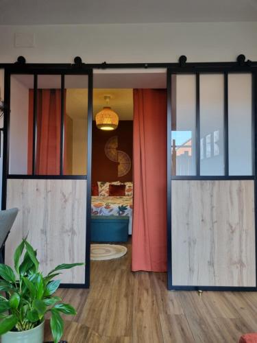 a room with sliding glass doors and a bedroom at Le Vauban Cambrai in Cambrai