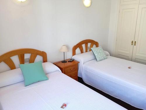 a bedroom with two beds and a table with a lamp at 1ª línea playa de Silgar en Sanxenxo, a 20 pasos in Sanxenxo