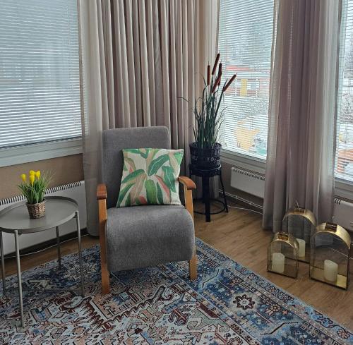 a living room with a chair and a table at Carelian Pearl - house in Ilomantsi, Eastern Finland in Ilomantsi