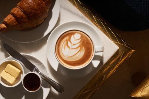 a cup of coffee and a plate of bread and butter at Pyramids Park Resort Cairo in Cairo