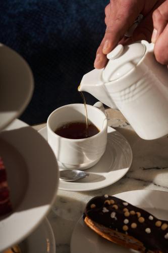 a person pouring coffee into a cup on a table at Pyramids Park Resort Cairo in Cairo