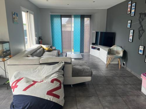 LanguidicにあるMaison de vacances 15 mn de la mer avec piscine hors solのソファとテレビのあるリビングルーム