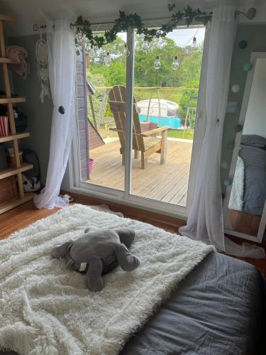 un éléphant farci dormant sur un lit dans une chambre dans l'établissement Maison de vacances 15 mn de la mer avec piscine hors sol, à Languidic