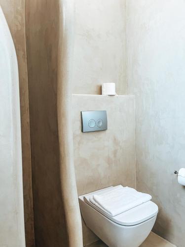 a bathroom with a white toilet and a sink at Cycladic Stone Studio in Ambelas