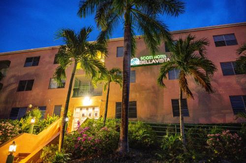 a building with a sign for a hotel with palm trees at Bellavista Scott Hotel in Charlotte Amalie