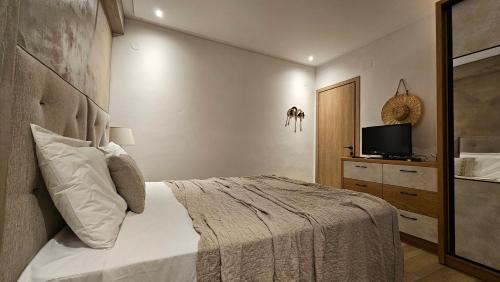 a bedroom with a large bed and a television at Philia Luxury Living in Nei Poroi