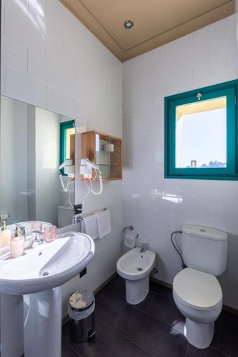 a white bathroom with a sink and a toilet at Els Jardins De La Martana in Besalú