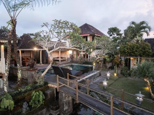 a house with a pond in front of it at Uma Caming Villa Ubud in Tegalalang