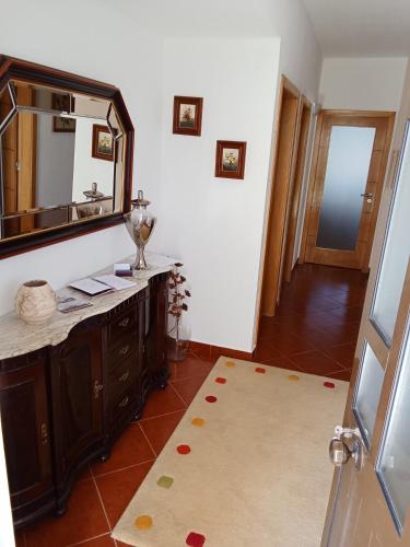 a bathroom with a vanity and a large mirror at Casa do Campo in Seia