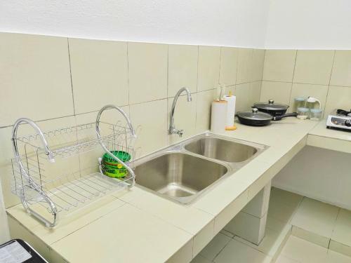 a kitchen with a sink and a counter top at GRANDE MAISON 3 NEAR AFAMOSA WaterPark in Kampong Pulau Sebang