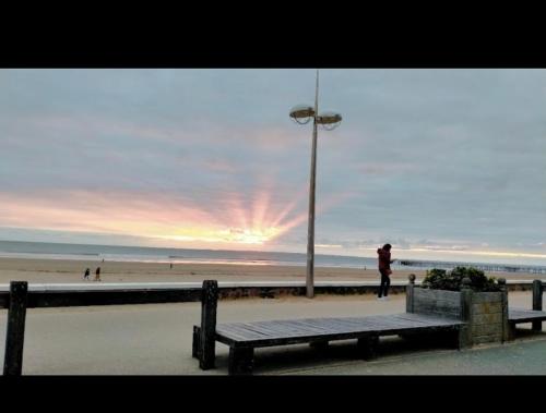 une personne debout à côté d'un banc sur une plage dans l'établissement Eddy et Anissia F123 pour 6 personnes, à Saint-Jean-de-Monts