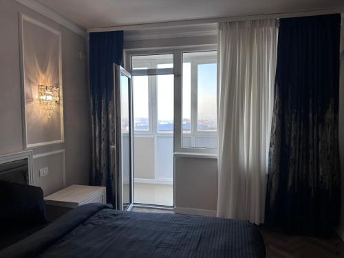 a bedroom with a bed and a large window at Prestige Royale Apartment in Craiova