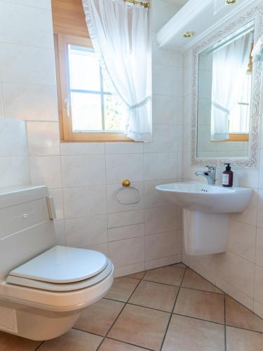 a bathroom with a toilet and a sink and a window at Orion - Luxuriöse Duplex Wohnung in Grindelwald in Grindelwald