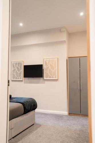 a bedroom with a bed and a refrigerator at Stunning 2 Bedroom Beach Apartment With Garden in Rhos-on-Sea