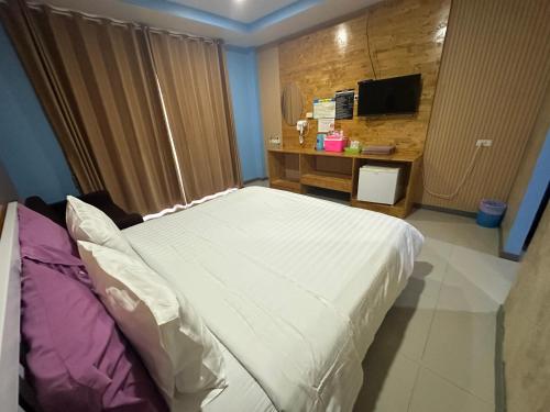 a bedroom with a bed and a desk with a television at Jingle Bells Resort in Ko Larn